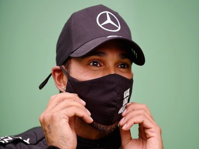 Le champion du monde britannique Lewis Hamilton ajuste son masque à l'issue du GP du Portugal sur l'Autodrome international d'Algarve, le 25 octobre 2020 à Portimao - JORGE GUERRERO [POOL/AFP/Archives]