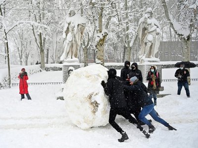 Des jeunes font une boule de neige géante dans une rue de Madrid, le 9 janvier 2021 - Gabriel BOUYS [AFP/Archives]