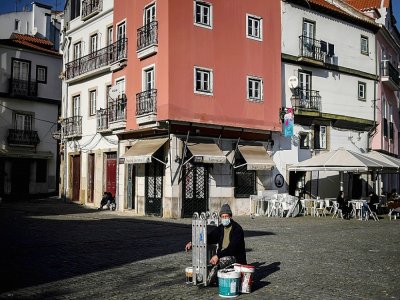 Un peintre dans le quartier de l'Alfama à Lisbonne le 13 janvier 2021 - PATRICIA DE MELO MOREIRA [AFP]