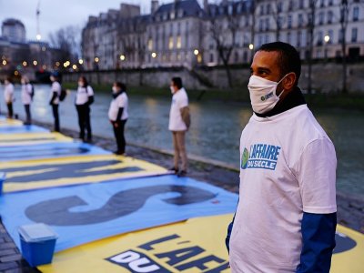 Un militant écologiste participe à une action le 14 janvier 2021 à Paris pour attirer l'attention sur le procès intenté à l'Etat par plusieurs ONG - Thomas SAMSON [AFP]