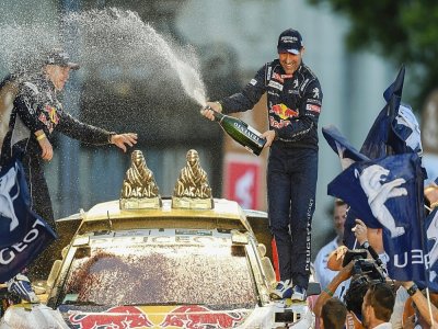 Le pilote de chez Peugeot, le Français Stéphane Peterhansel (d) et son co-pilote Jean-Paul Cottret, célèbrent leur victoire dans le Rallye Dakar, le 14 janvier 2017 à Buenos Aires - EITAN ABRAMOVICH [AFP/Archives]