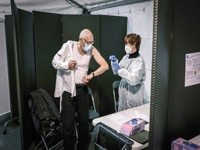 Un homme se fait vacciner contre le Covid-19 au Palais des sports de Lyon, utilisé comme centre de vaccination, le 14 janvier 2021 - JEAN-PHILIPPE KSIAZEK [AFP]