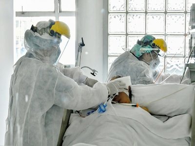 Deux infirmiers s'affairent autour d'un malade atteitn du Covid-19 à l'hôpital Santa Clara de Bogota (Colombie), le 15 janvier 2021. - STR [AFP]