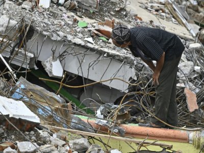 Un homme après la découverte du corps d'un de ses proches dans les débris d'un bâtiment détruit, au lendemain d'un séisme sur l'île indonésienne de Célèbres, à Mamuju, le 16 janvier 2021 - Hariandi Hafid, Hariandi Hafid [AFP]