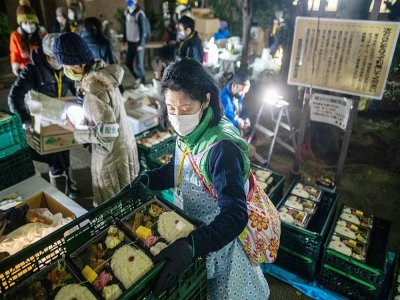 Des bénévoles rpéparent des colis alimentaires pour des personnes dans le besoin, à Tokyo, le 9 janvier 2021 - Philip FONG [AFP]