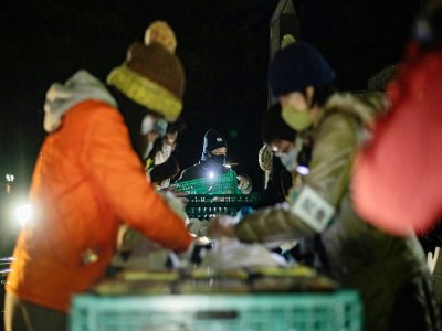 Des volontaires distribuent des colis à des personnes dans le besoin le 9 janvier 2021 à Tokyo - Philip FONG [AFP]