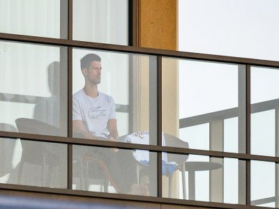 Le Serbe Novak Djokovic au balcon de son hôtel à Adelaïde, où il a été mis en quarantaine à son arrivée, le 18 janvier 2021 - Brenton EDWARDS [AFP]