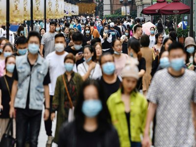Des piétons masqués dans une rue de Wuhan, le 27 septembre 2020 - Hector RETAMAL [AFP/Archives]