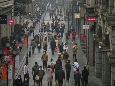 Des piétons dans une rue de Wuhan, le 23 janvier 2021 en Chine - Hector RETAMAL [AFP]