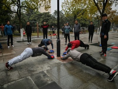 Des habitants font de l'exercice dans un parc de Wuhan, le 23 janvier 2021 en Chine - Hector RETAMAL [AFP]