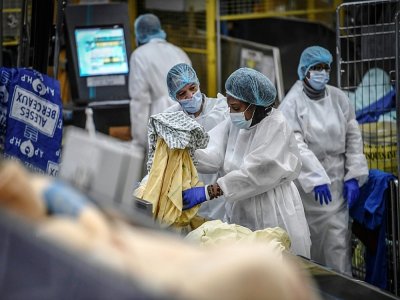 Des employés dans la blanchisserie centrale de l'hôpital de La Pitié-Salpétrière à Paris, le 26 janvier 2021 - STEPHANE DE SAKUTIN [AFP]