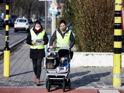 Des volontaires se promènent avec Claire dans sa poussette, une poupée équipée de capteurs pour mesurer la pollution de l'air, à Anvers (Belgique) le 25 janvier 2021. - Kenzo TRIBOUILLARD [AFP]