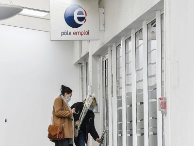 Deux femmes déposent des fleurs, le 29 janvier 2021, devant l'agence Pôle Emploi de Valence, où une conseillère a été tuée la veille. - PHILIPPE DESMAZES [AFP]