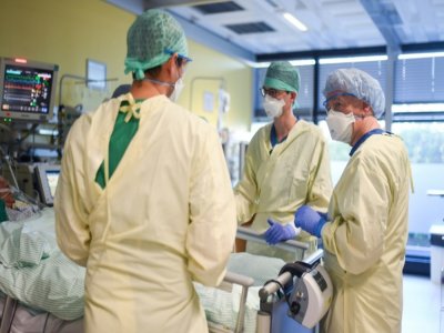 Gernot Marx (d) avec des collègues examinent un patient atteint du Covid-19 à l'hôpital universitaire d'Aix-la-Chapelle, le 20 janvier 2021 - Ina FASSBENDER [AFP]
