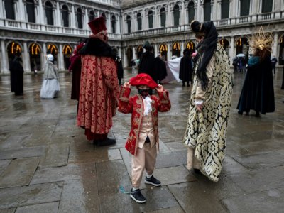 Des Vénitiens déguisés pour le carnaval sur la place Saint-Marc de Venise (Italie), le 7 février 2021 - Marco Bertorello [AFP]