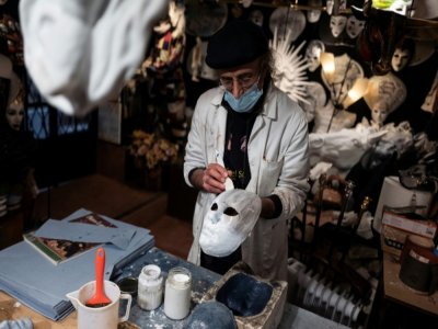 L'artisan Hamid Seddighi fabrique un masque de papier mâché dans sa boutique "Ca del Sol" à Venise, le 6 février 2021 - Marco Bertorello [AFP]