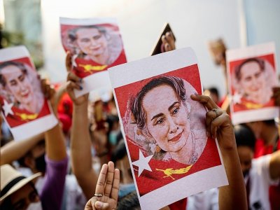 Des portraits d'Aung San Suu Kyi sont brandis par des manifestants devant l'ambassade de Birmanie à Bangkok, le 7 février 2021 - Jack TAYLOR [AFP]
