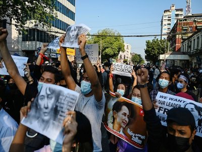 Des manifestants anti-coup d'Etat brandissent des portraits d'Aung San Suu Kyi, le 8 février 2021 à Rangoun - YE AUNG THU [AFP]