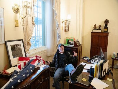Richard Barnett, un partisan de Donald Trump, assis dans le bureau de la présidente démocrate de la Chambre des représentants Nancy Pelosi, lors du violent assaut du Capitole à Washington le 6 janvier 2021 - SAUL LOEB [AFP/Archives]
