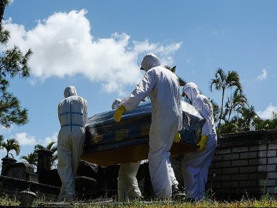 Des employés de pompes funèbres portent un cercueil le 8 janvier 2021 à Tegucigalpa (Honduras) - Orlando SIERRA [AFP]