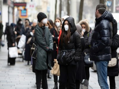 Des personnes portent des masques FFP2 dans la rue, le 8 février 2021 à Vienne, en Autriche - ALEX HALADA [AFP]
