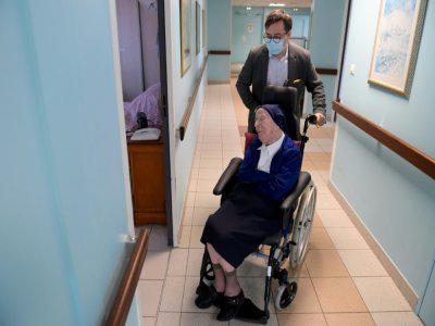 Soeur André, qui aura 117 ans jeudi, assise dans son fauteuil roulant, dans un couloir de son Ehpad de Toulon, le 10 février 2021 - NICOLAS TUCAT [AFP]