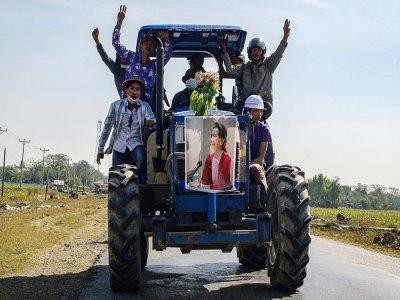 Des agriculteurs brandissent le portrait de leur leader Aung San Suu Kyi près de Rangoun, le 12 février 2021 - STR [AFP]