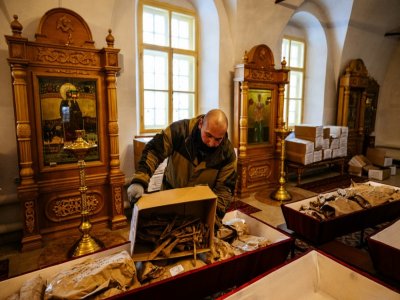 Un employé manipule mes cercueils contenant les restes de soldats russes et français morts lors de la retraite de Russie en 1812, le 8 février 2021 à Viazma - Dimitar DILKOFF [AFP]