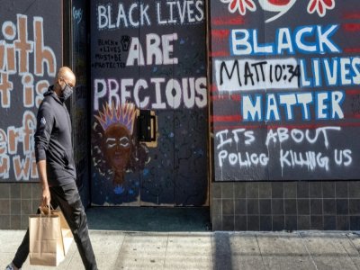 Un Afro-Américain passe devant un mur couvert de messages Black Lives Matter à Oakland, en Californie, le 12 février 2021 - JOSH EDELSON [AFP]