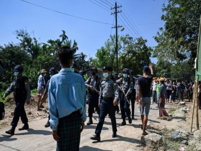 Des policiers birmans venus dans un quartier de Rangoun chercher des cheminots en grève pour les forcer à reprendre le travail s'en vont bredouilles face aux habitants du quartier qui les ont empêché d'entrer, le 14 février 2021 - YE AUNG THU [AFP]