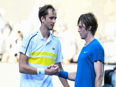 Le Russe Danill Medvedev (g) console son compatriote Andrey Rublev, après leur quart de finale de l'Open d'Australie, le 17 février 2021 à Melbourne - William WEST [AFP]