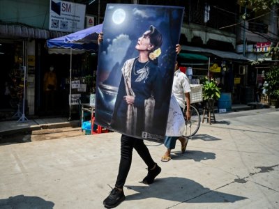 Un manifestant porte un grand portrait de Aung San Suu Kyi, arrêtée après le coup d'Etat militaire en Birmanie, à Rangoun le 20 février 2021 - YE AUNG THU [AFP]