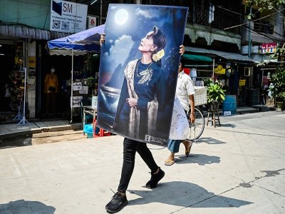 Un manifestant porte un grand portrait de Aung San Suu Kyi, arrêtée après le coup d'Etat militaire en Birmanie, à Rangoun le 20 février 2021 - YE AUNG THU [AFP]