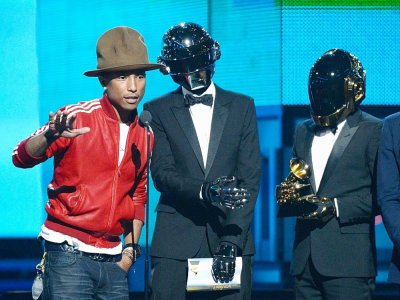 Les Daft Punk et Pharrell Williams le 26 janvier 2014 lors de la cérémonie des 56è GRAMMY Awards. Leur single "Get Lucky" est devenu le tube planétaire de 2013 - KEVORK DJANSEZIAN [GETTY IMAGES NORTH AMERICA/AFP/Archives]