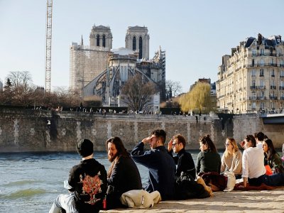 Des personnes se rassemblent le long de la Seine pour profiter d'un après-midi ensoleillé, à Paris, le 28 février 2021 - Thomas COEX [AFP]