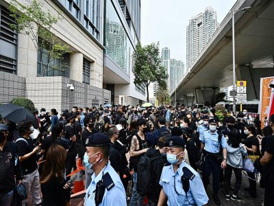 Des agents de police passent entre les manifestants postés devant le tribunal de Kowloon à Hong-Kong le 1er mars 2021 - Anthony WALLACE [AFP]