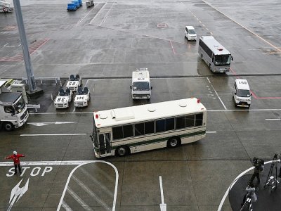 Un bus, qui transporterait les deux Américains accusés d'avoir aidé Carlos Ghosn dans sa fuite, quitte l'aéroport de Narita, le 2 mars 2021 au Japon - Kazuhiro NOGI [AFP]
