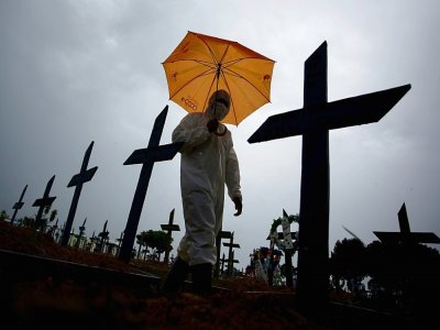 Un homme marche le long de tombes de victimes du covid le 25 février 2021 à Manous (Brésil) - MICHAEL DANTAS [AFP/Archives]