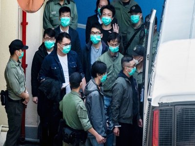 Des militants pro-démocratie escortés par la police lors d'un transfert, au lendemain d'une comparution devant le tribunal de West Kowloon, le 2 mars 2021 à Hong Kong - VERNON YUEN [AFP]