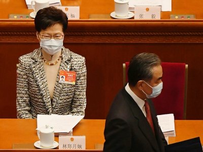 Le ministre chinois des Affaire étrangères Wang Yi (d) devant la cheffe de l'exécutif de Hong Kong Carrie Lam, lors de la session plénière annuelle du Parlement à Pékin, le 5 mars 2021 - LEO RAMIREZ [AFP]