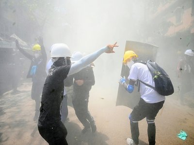 Manifestants pro-démocratie enfumés par des gaz lacrymogènes à Rangoun, le 7 mars 2021 - STR [AFP]
