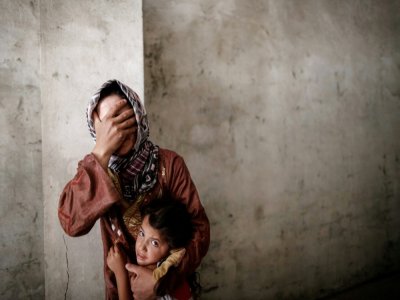 Une Syrienne et sa fille pendant une frappe aérienne près de sa maison près d'Alep, le 13 septembre 2012 - Sam TARLING [AFP/Archives]