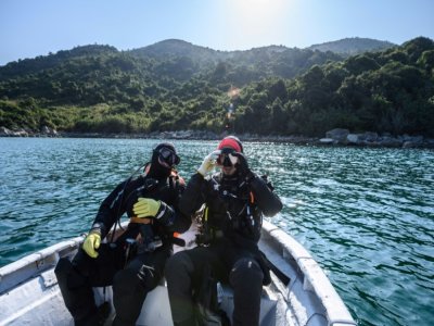 Des scientifiques de l'université de Hong Kong  se préparent à plonger dans les eaux du parc marin de Hoi Ha Wan à Hong Kong, le 2 février 2021 - Anthony WALLACE [AFP]