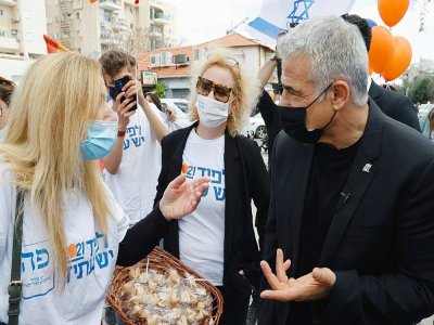 Le président du parti d'opposition israélien Yesh Atid, Yaïr Lapid, fait campagne dans la ville méditerranéenne de Hod Hasharon, dans le centre d'Israël, le 19 mars 2021. - JACK GUEZ [AFP]