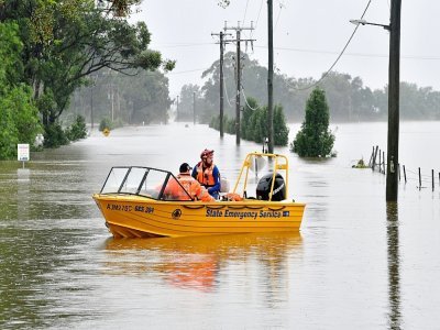 Des services de secours en bateau dans une zone résidentielle inondée de Windsor, le 23 mars 2021 en Australie - Saeed KHAN [AFP]