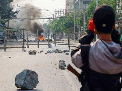 Un manifestant regarde une barrricade incendiée, le 22 mars 2021 à Mandalay, en Birmanie - STR [AFP]
