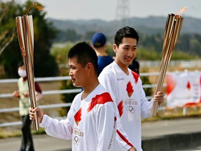 Des relayeurs pendant la première journée du relais de la torche olympique à Naraha (Japon) le 25 mars 2021 - CHARLY TRIBALLEAU [AFP]