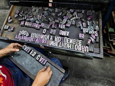 Le maître imprimeur Olmedo Franco assemble des plombs utilisés sur la machine Reliance de 1890 fabriquée à New York, dans l'imprimerie La Linterna, le 2 mars 2021 à Cali, en Colombie - Luis ROBAYO [AFP]