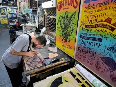 L'artiste Tonra travaille sur un dessin à l'imprimerie La Linterna, le 2 mars 2021 à Cali, en Colombie - Luis ROBAYO [AFP]