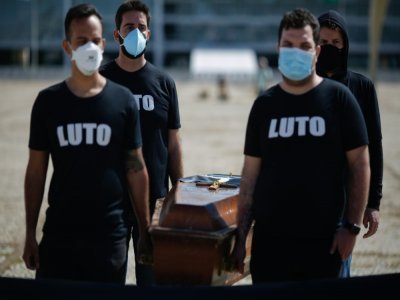 Des membres du personnel de Santé portent un cercueil à Brasilia le 25 mars 2021 pour dénoncer la mort de 300.000 personnes victimes du Covid-19 au Brésil - Sergio Lima [AFP]